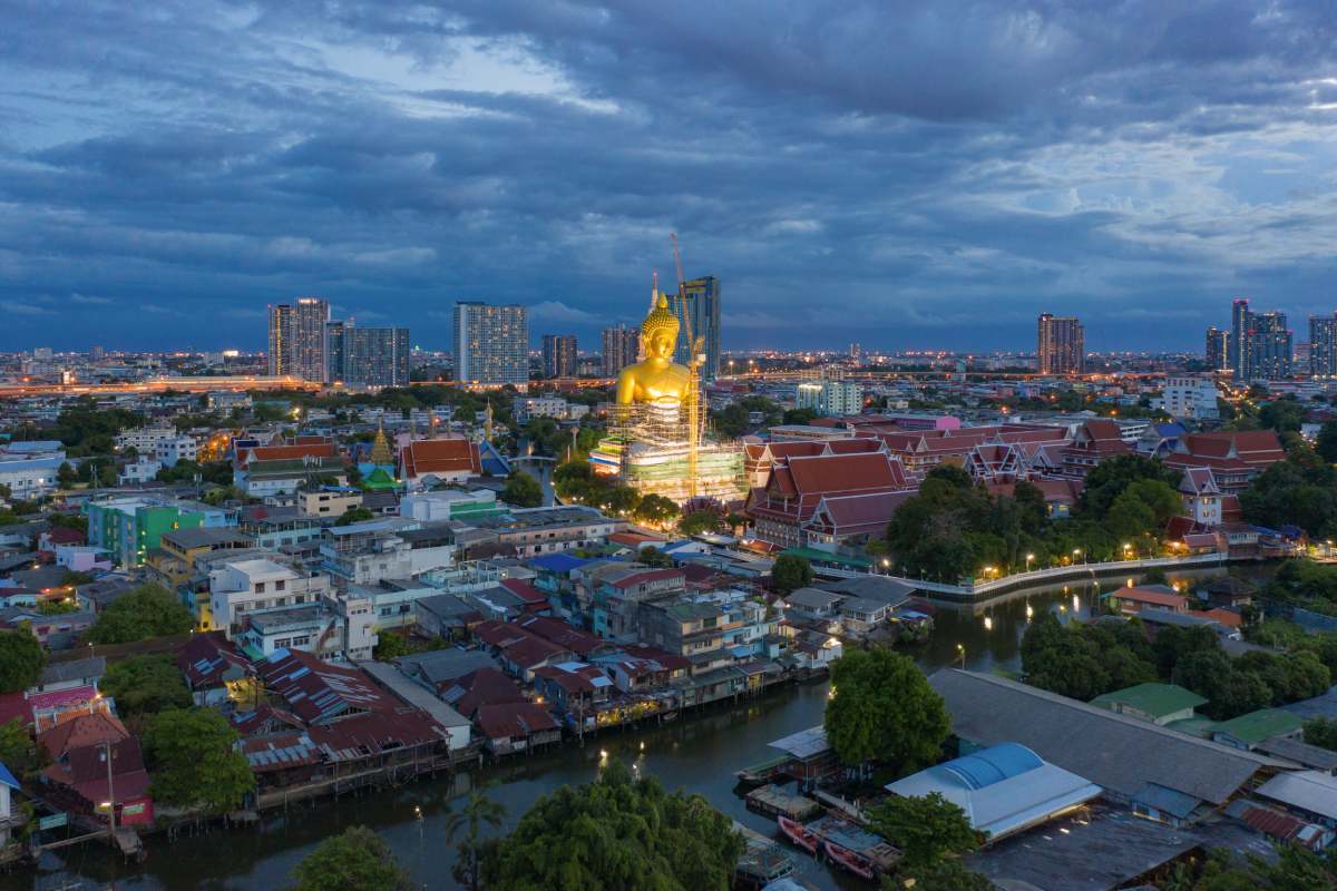 Aerial view of the Giant Golden Buddha in Wat Paknam Phasi Charoen Temple in Phasi Charoen district on Chao Phraya River at night, Bangkok. Urban town, Thailand. Downtown City.
